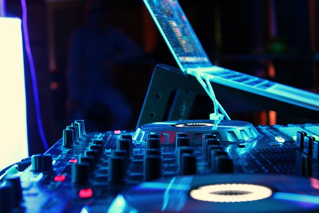 DJ utilizando una controladora y un ordenador para analizar y mezclar música